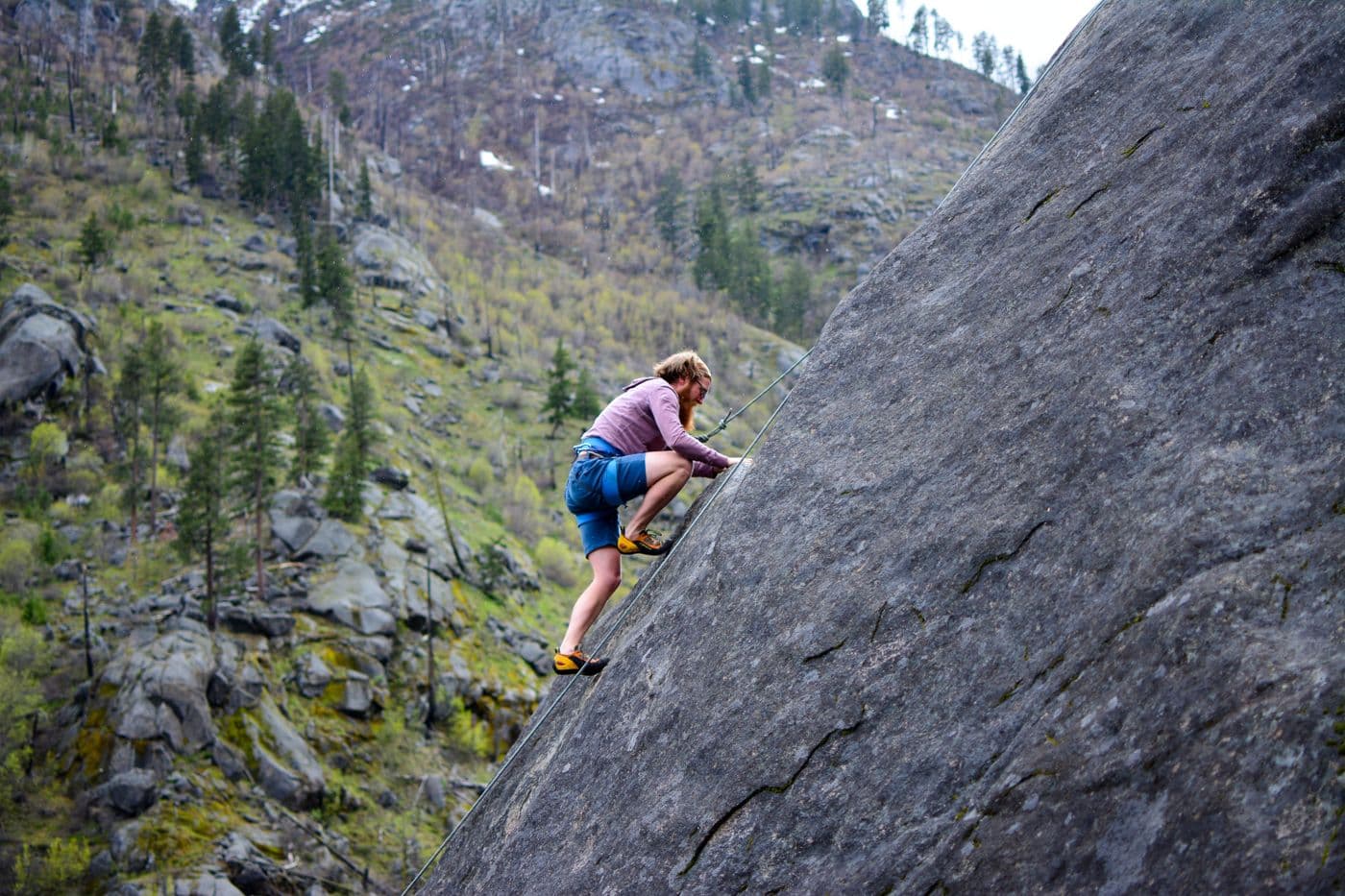 Rock climber with technical outdoor gear on a mountain face